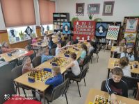 Uczniowie przy stolikach grają w szachy